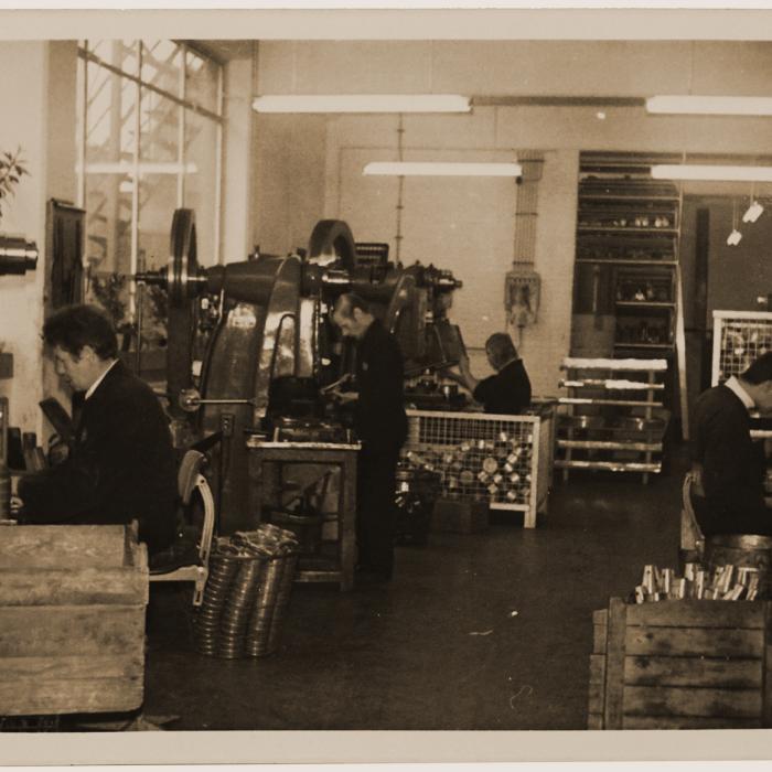 Factory workers hemming cups on eccentric presses